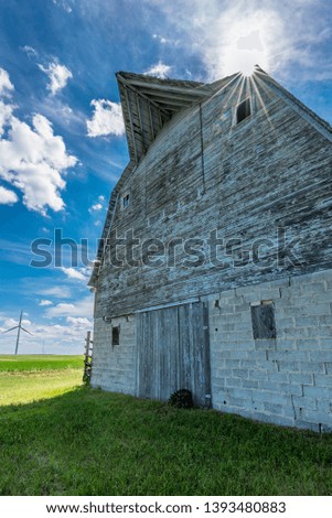 Old weathered barn on the prairies with wind turbines in the background