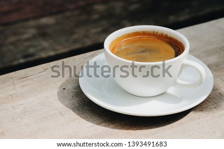 Cup of americano coffee on wooden table Royalty-Free Stock Photo #1393491683