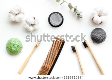 eco friendly bamboo tooth brush and carbon toothpaste, comb, organic soap on white background top view