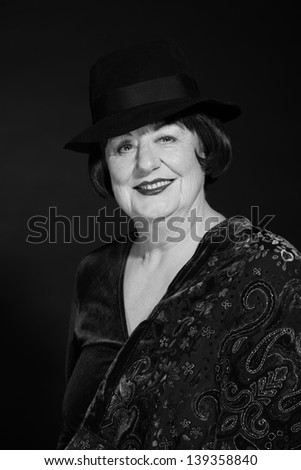 Retro glamour studio portrait of senior woman. Black and white photo.