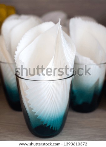 White clean tissue paper in retro style glass on wooden table vertical style.