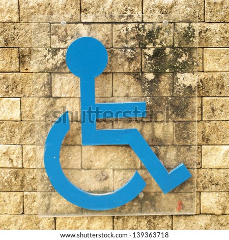 disabled person sign on brick wall