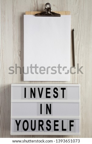 Modern board with 'You are your only limit' words, clipboard with blank sheet on a white wooden background, top view. Space for text.