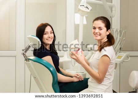 Beautiful woman patient having dental treatment at dentist's office. Doctor holds the medical jaw