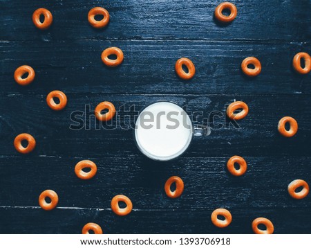 cup of milk and bagels on a black background