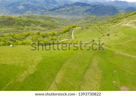 Top view or aerial shot of fresh green spring hills and meadows in the Apuseni Mounstains, Transilvania.