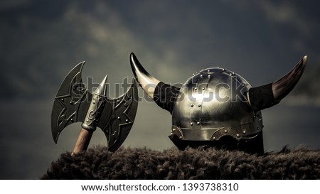 Viking helmet with axe on fjord shore in Norway. Tourism and traveling concept Royalty-Free Stock Photo #1393738310