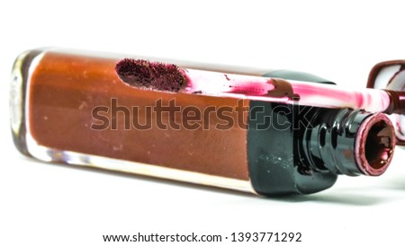 Old lip gloss, with glitter particles in elegant glass bottle with golden lid, closed and open container with brush and stroke sample, isolated on white background.