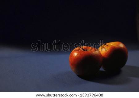 Two red apples on classic trendy color of the year 2020 blue background