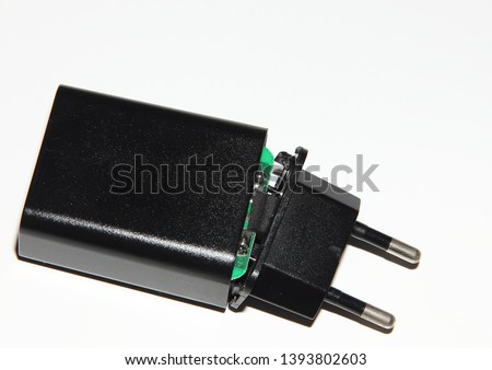 broken black charging from mobile phone on white background
