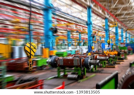 Inside Moving Assembly Line of the Large industrial shop truck plant. Bridge Crane Hook against the background of the industrial factory. Manufacturing Facilities. Motion blur effect  Royalty-Free Stock Photo #1393813505