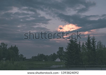 dramatic clouds on red sky over city roof tops at sunset - vintage retro look