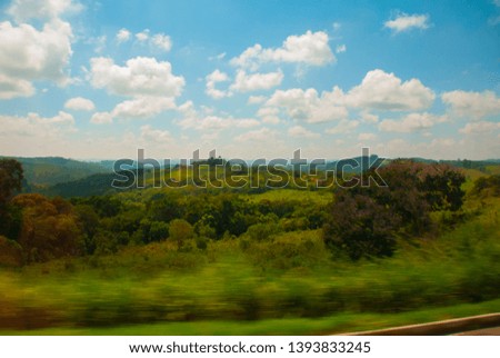 Beautiful landscape overlooking fields and hills with white clouds and blue sky. Brazil