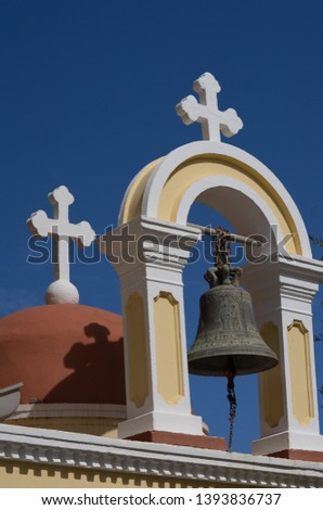 Detail of the clock tower and the church bell of the Greek orthodox cathedral in front of bright blue sky in Palaiochora, Crete, Greece. (Translation on the bell: Palaiochora, Xanion 17-3-1946)