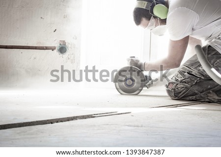 worker cuts concrete floor with electrical flex