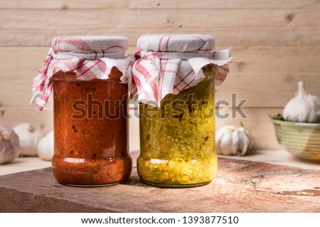 Jars of south Indian spicy green chilly pickle and garlic pickle  on a wooden rustic background  Royalty-Free Stock Photo #1393877510