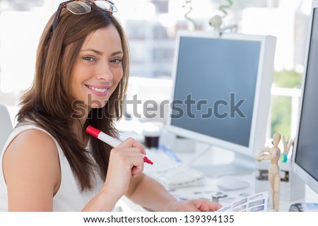 Photo editor about to make some cuts in the office at her desk Royalty-Free Stock Photo #139394135
