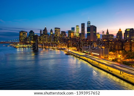 New York, USA. Aerial view on the city skyline in New York City, USA during the sunset. Famous skyscrapers of the concrete jungle and car traffic. Brooklyn Bridge