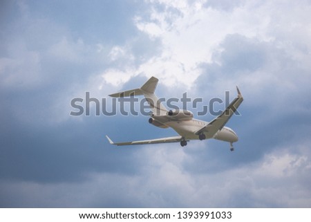 Close-up of a passenger plane flying against on the background of a stormy sky and clouds