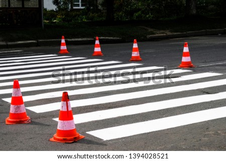 Caring for a road in a small city. Zebra crossings. Traffic cones are warned.
