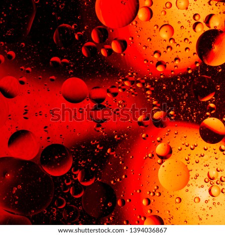Mixing water and oil in red abstract background gradient balls circles and ovals