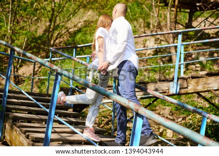 young hugging couple on stairs in green park