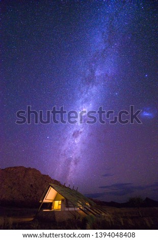 Milky way over a small chalet of a desert lodge near the Namib-Naukluft National Park close to Sossusvlei in Namibia. Night photo with many stars.
