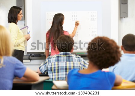 Female Student Writing Answer On Whiteboard