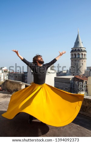 Whirling man Dervish or Semazen in Istanbul, Turkey. Galata Tower and city in background  