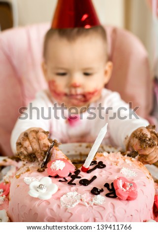 one-year-old little girl with  dirty-faced solemnize birthday, vertical photo
