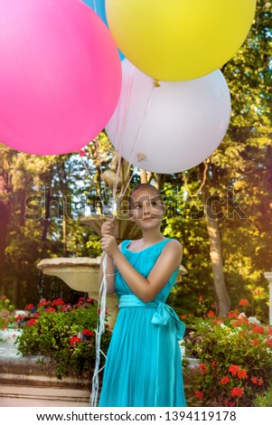 Pretty young girl with big colorful balloons walking in the park - image. Air balloons. Holiday party, birthday. 