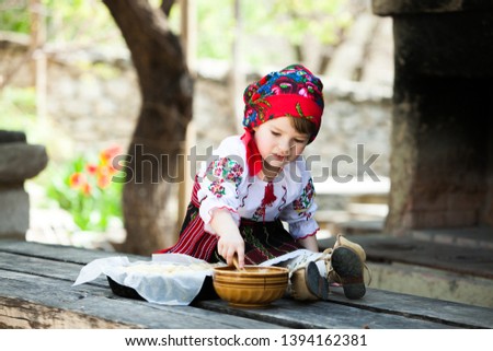Little girl in traditional Romanian folk costume with embroidery. Girl in Romanian dress. Romanian folklore