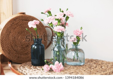 home interior decoration: flowers in vintage bottles and a wicker bag on the shelves - image