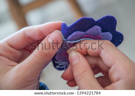 Handmade felt brooch making. Children's hands sew a brooch. Cute gift for mom birthday or Mother's day. Concept of education and games for children.
