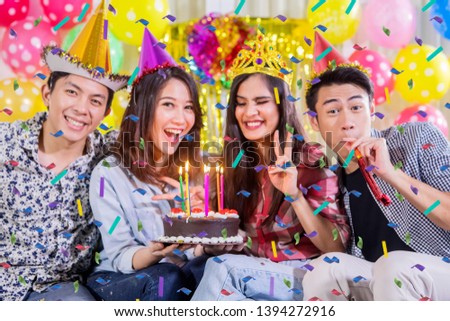 Picture of four young people celebrating birthday party while smiling at the camera at home