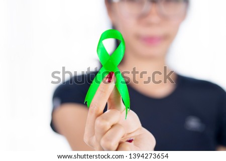 Lymphoma cancer concept. Picture of unknown woman holding a green lime ribbon, isolated on white background