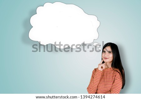 Picture of young pretty girl thinking an idea while looking at an empty cloud bubble