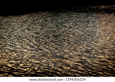 Reflections in the surface of water at sunset, Pouawa Lagoon, near Gisborne, East Coast, North Island, New Zealand 