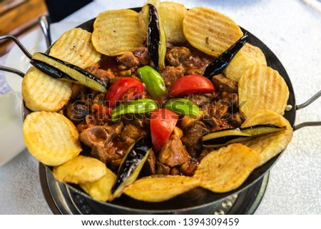 Pan-fried sac dish with meat, vegetables, mushrooms and potato, served on a hotplate at a restaurant in Azerbaijan. Royalty-Free Stock Photo #1394309459