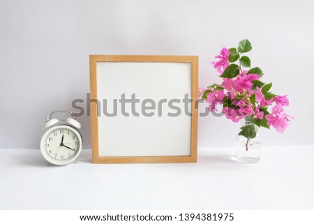 blank square frame styled with flowers and clock