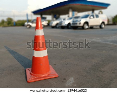 Red rubber cone on concrete floor in gas station, blurred background image
