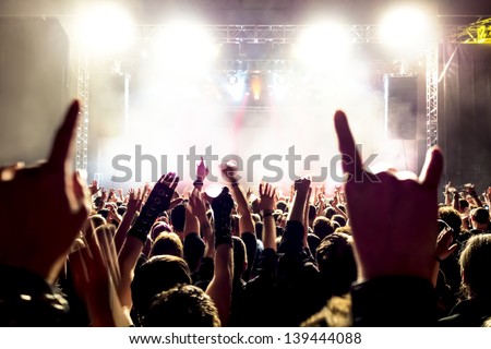 cheering crowd in front of bright stage lights Royalty-Free Stock Photo #139444088