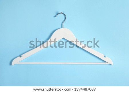 Empty clothes hanger on color background. Wardrobe accessory