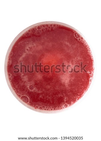 Top view of red effervescent tablet of vitamin B pill dissolve with bubbles in the fresh drink water in white ceramic cup on white background 