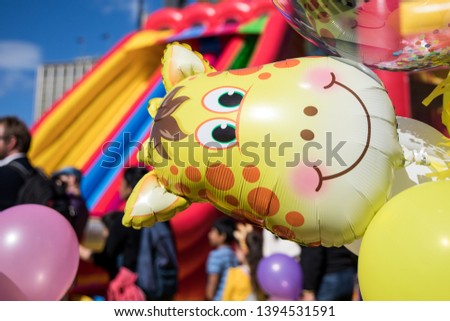 Bright yellow giraffe face balloon on sunny day at a kids carnival party