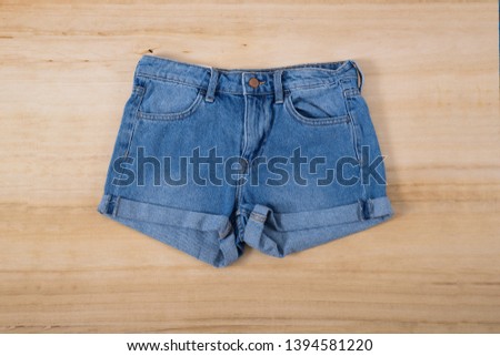 Close up Blue shorts Jeans denim on wooden background 
