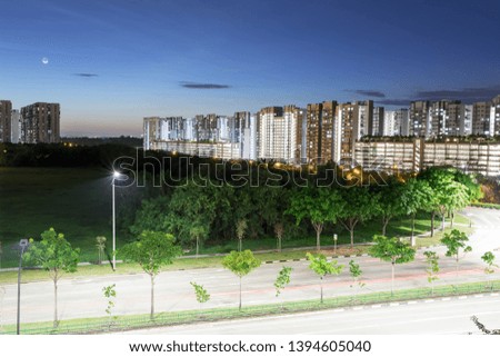 Night shot of condominium with moon, blue sky and night lights. landscape slow shutter shot of residential condos with car trails, nice lights, blue sky and moon
