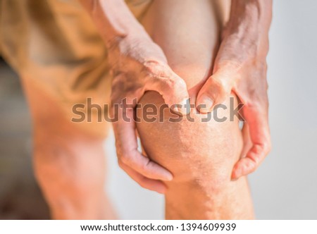 Hands that are holding knees that have problems with the deterioration of the bones of the elderly Royalty-Free Stock Photo #1394609939