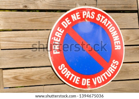 French no parking sign on a wooden gate
