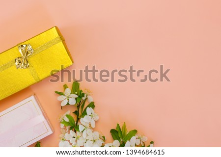 Long gift boxes and spring flowers on pink background. Copy space. Spring shopping concept.